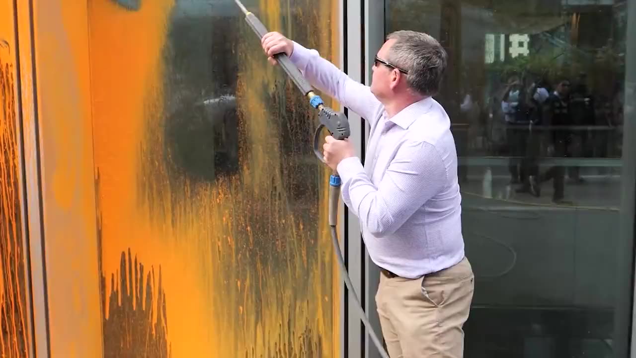 Man washes off paint from a Just Stop Oil protest