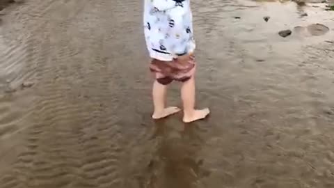 The children are splashing in the puddles