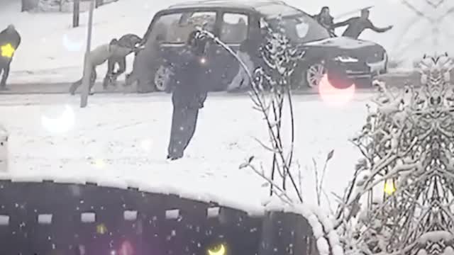 A group of strangers in England came together to help move a hearse after it got stuck in the snow.