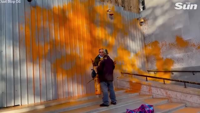 Moment bystander tires to stop eco-warrior activist from spray painting MI5 HQ