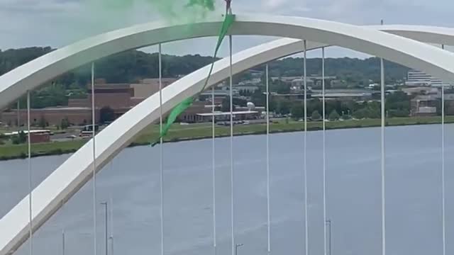 Man protesting Supreme Court decision on abortion at the top of the Frederick Douglass Bridge