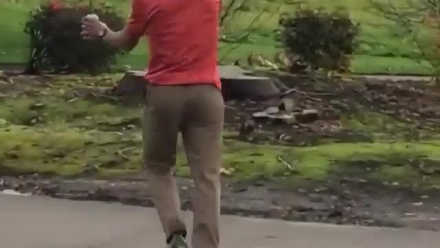 A man in orange jumped across a small river and landed safely