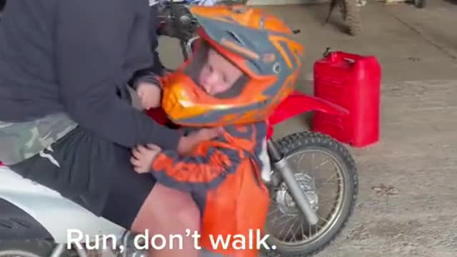 A child experiences a motorcycle with his father