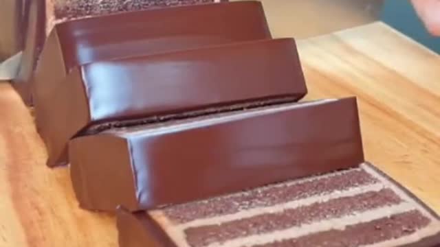 Elegant motion cuts through a multi-layered chocolate cake dessert