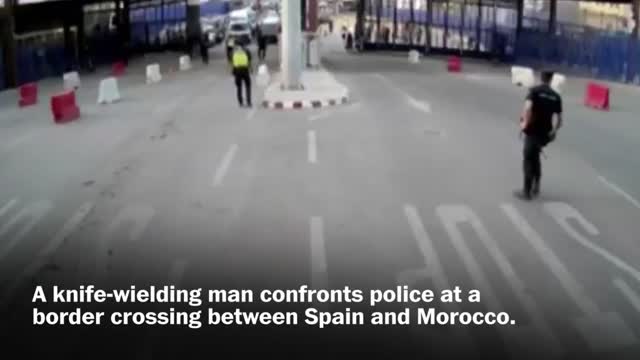 Spanish police throw traffic barrier at knife-wielding man