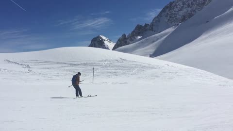 Skier Takes Off One Of His Skis, Flips It And Balances It On His Foot While Smoothly Going On Snow