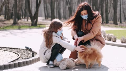 Mother and Daughter with Face Masks at the Park With Dog