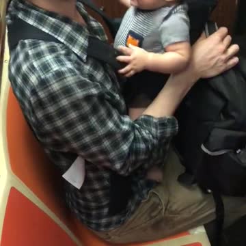 Train leaking water next to man with baby