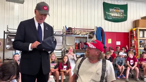 Biden grins as he dons a MAGA hat