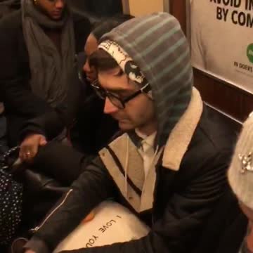 Guy sitting on subway hoodie looks like fiverr ad sign wall