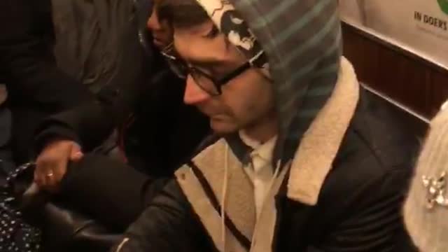 Guy sitting on subway hoodie looks like fiverr ad sign wall