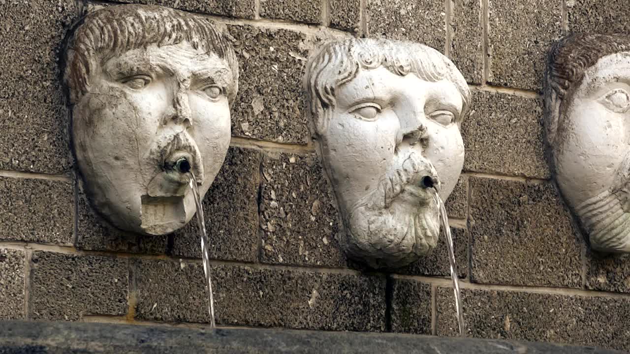 Water falling from human face statues