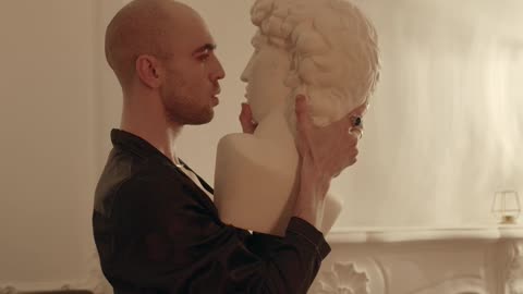 Man Dancing Holding a Head Bust