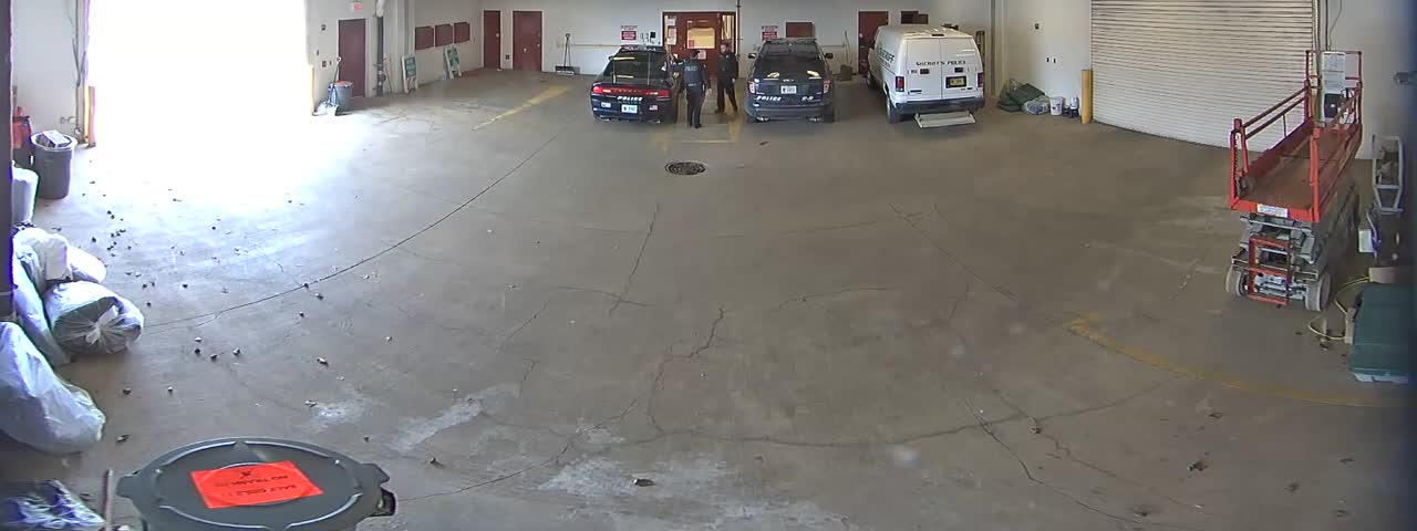 Watch How This Witty Perp Escapes Police Car Through Garage Doors