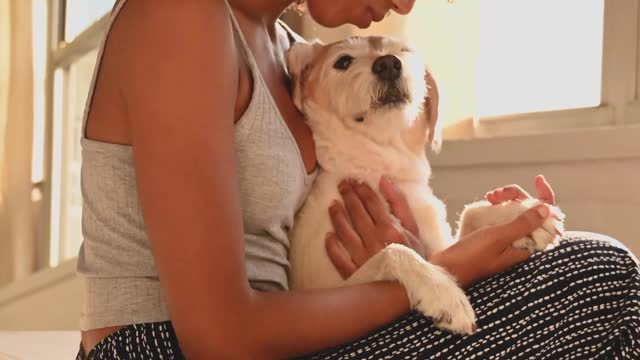 A Woman Sitting on Bed with her Dog