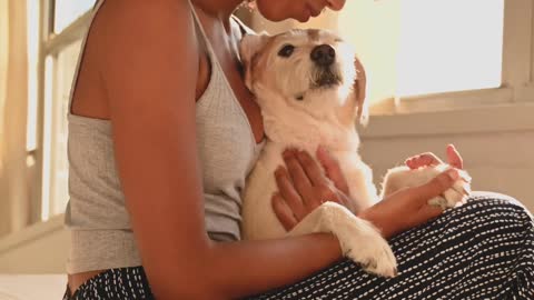 A Woman Sitting on Bed with her Dog