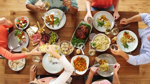 group of people eating at table with food