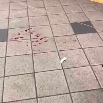 Red blood liquid on floor of subway station platform footprint