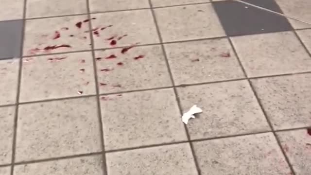 Red blood liquid on floor of subway station platform footprint