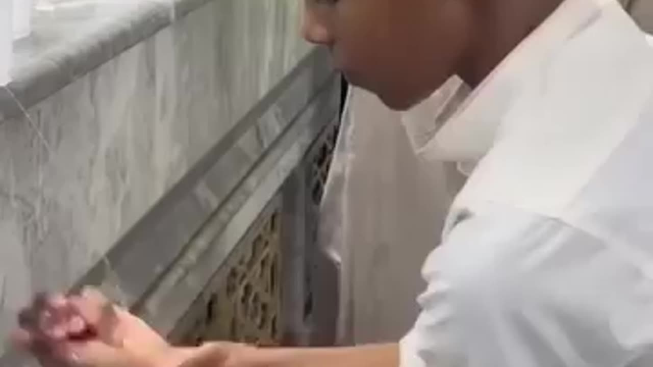 Very beautiful child performing ablution with a cup of water