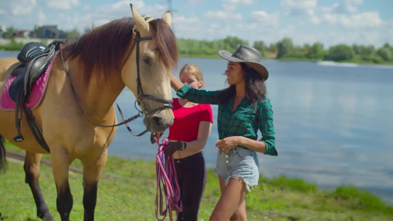 Positive young girl riding instructor teaching attractive african american