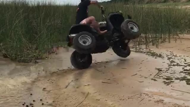 Man on black four wheeler flips