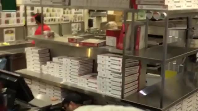 Guy wearing hat smoking cigarette inside five guys burgers