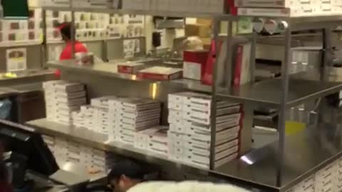 Guy wearing hat smoking cigarette inside five guys burgers