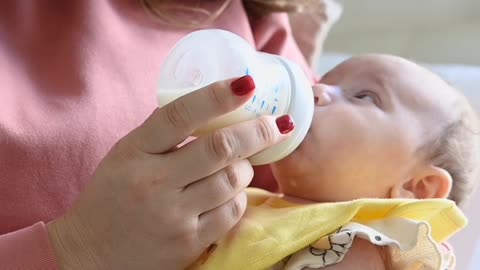 A mother is Breastfeeding Her baby With Relexing music