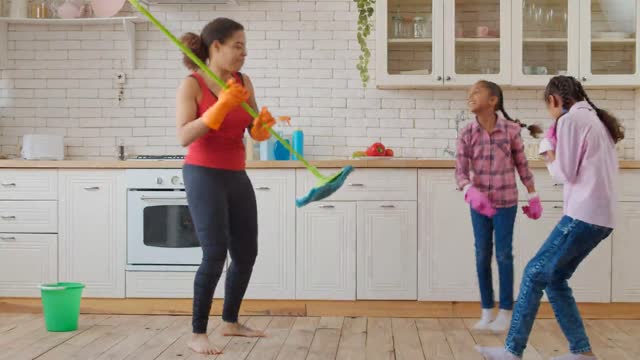 mother and daughters dance in their house