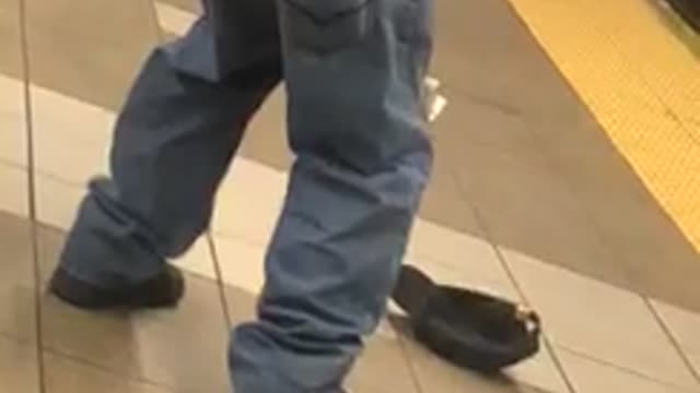 Man bends over showing his buttcrack and scratches his butt, in subway station