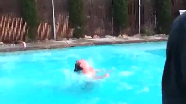 Shirtless guy grey shorts belly flop roof