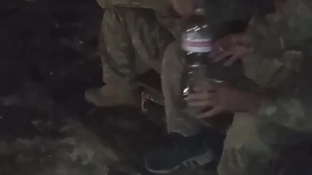 Russian soldier shares cigarettes with Ukrainian POWs.