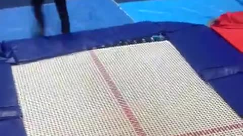 Black shirt kid frontflips off blue trampoline and faceplants into blue mat