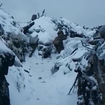 A Ukrainian soldier narrowly avoids artillery fire landing close by, ending up covered in snow