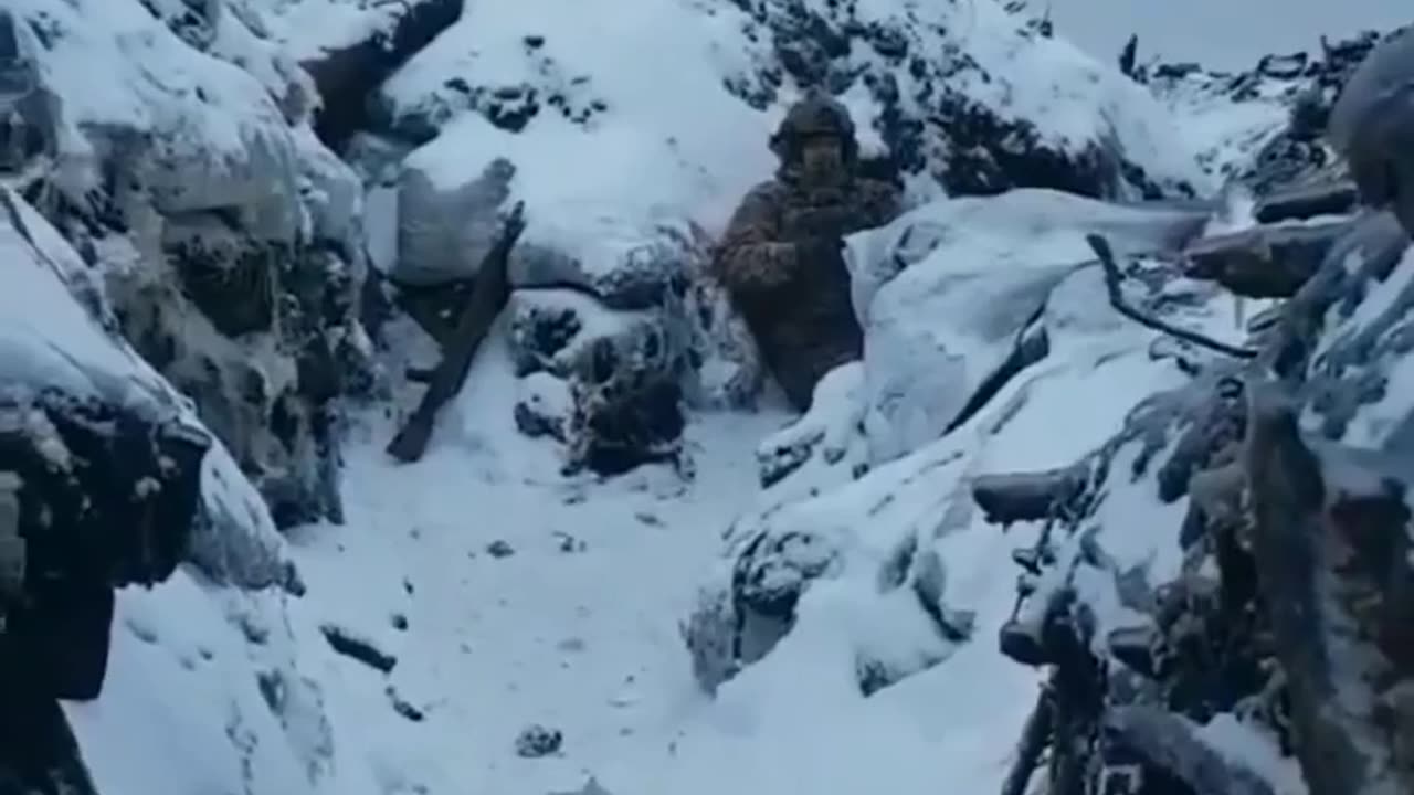 A Ukrainian soldier narrowly avoids artillery fire landing close by, ending up covered in snow