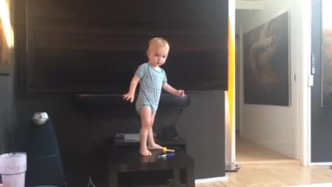 Smart baby climbed on the little table