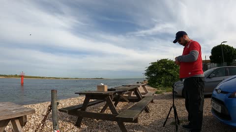 Setting up the camera for an unboxing video by the sea