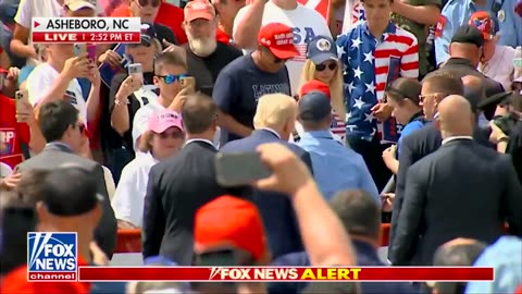 Trump walks out of bulletproof glass to hug a fan