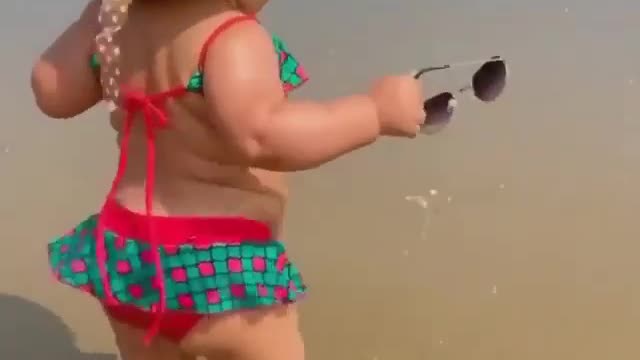 Look at this cute baby girl going near the beach in many attitudes