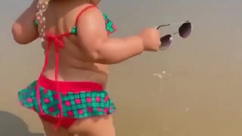 Look at this cute baby girl going near the beach in many attitudes