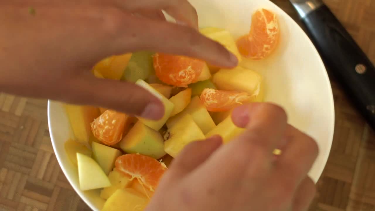 Close Up of Female Hands Mixing Bowl of Salad