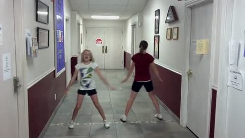 Two little girls are dancing in the passage