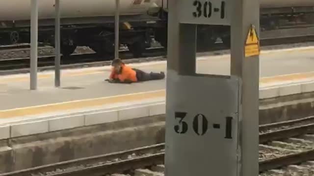 Chill out bro man in orange laying on train platform