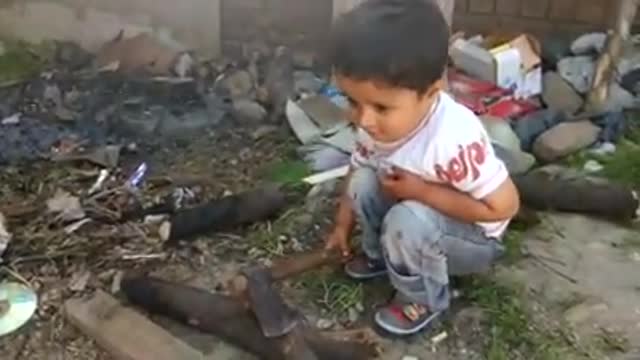 Very Small boy Playing with Axe