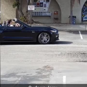 Surfs up jerry blue surfboard driven in back of car with top down