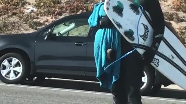 Guy covered in white sunblock grabs board to go surfing