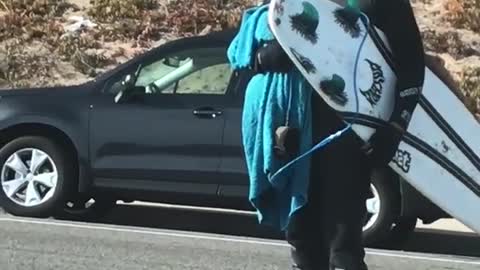 Guy covered in white sunblock grabs board to go surfing