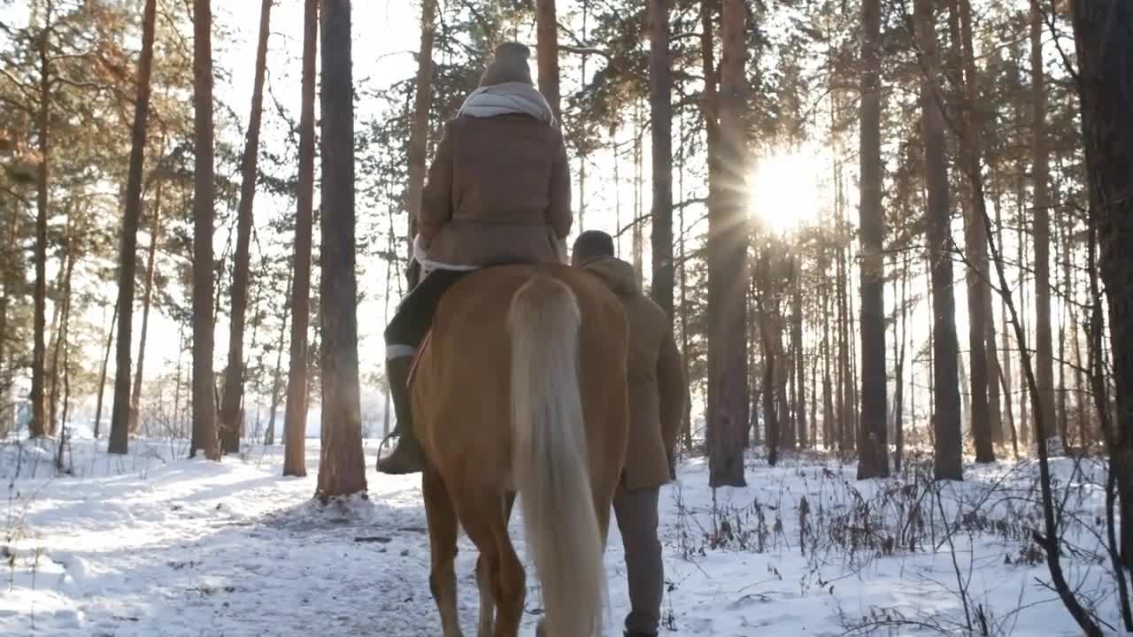 Back view of woman riding horse