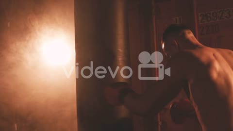 Shirtless Boxer Man Warms Up By Hitting The Punching Bag 1